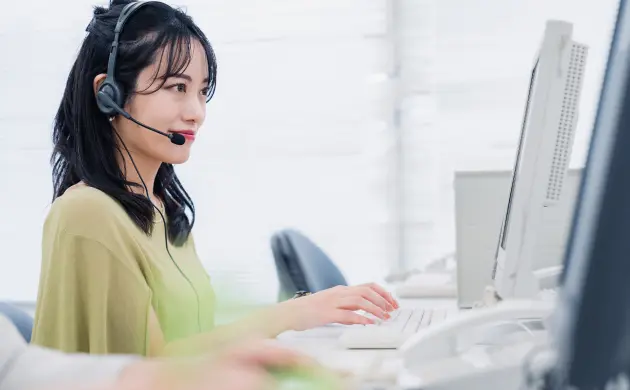 コールセンターで対応する女性スタッフの写真