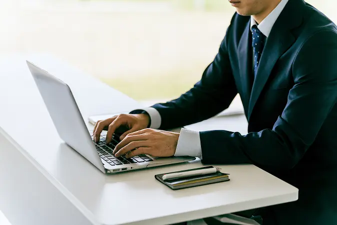 男性がパソコンに向かっている画像